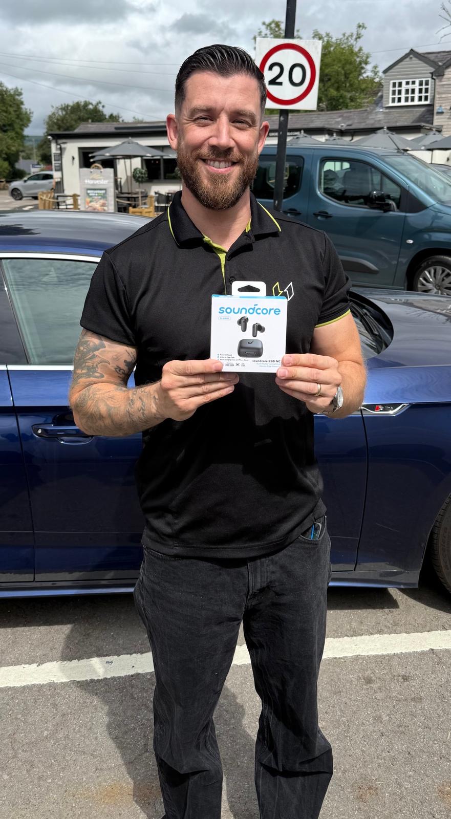 William Winter with their Soundcore R50i Wireless Earbuds prize from Coast Competitions